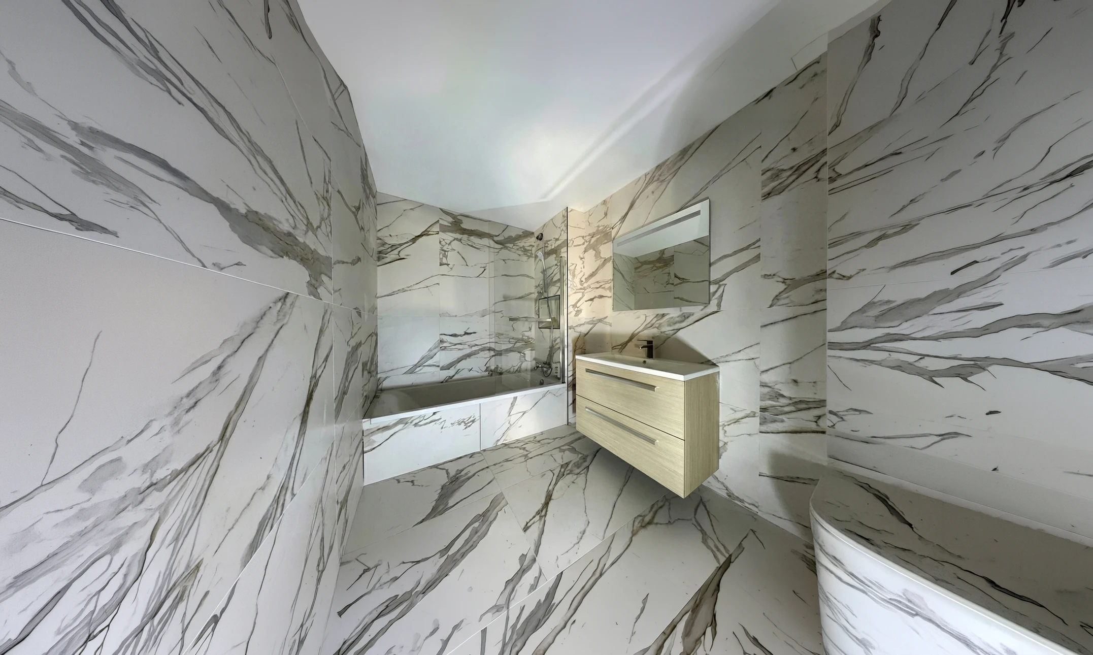 Salle de bain moderne entièrement habillée de grandes dalles effet marbre blanc veiné gris type Calacatta