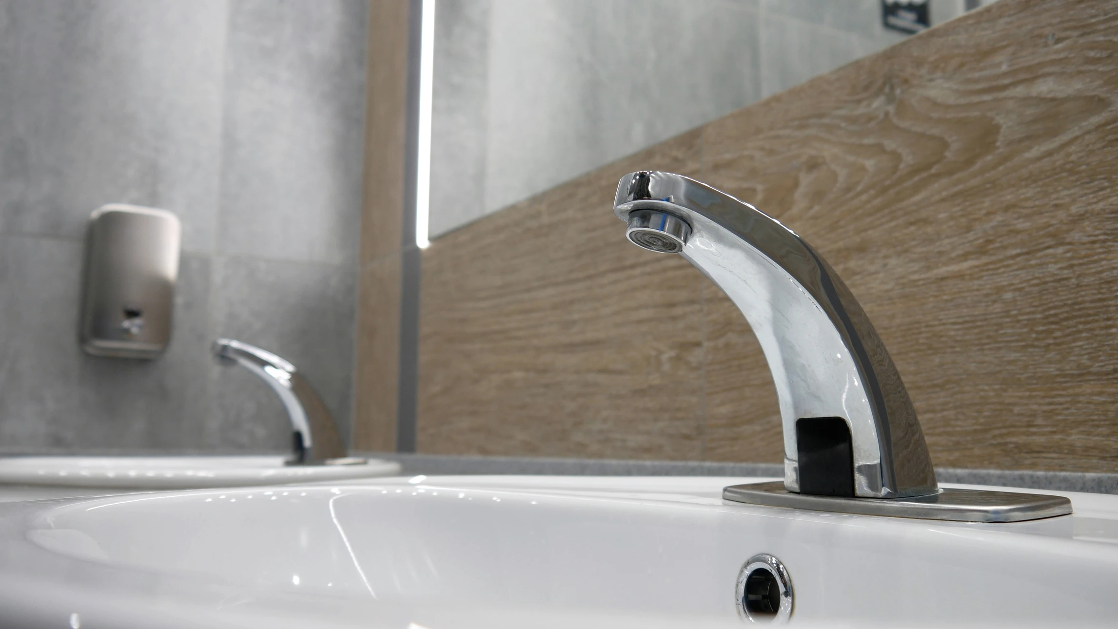 Robinet de cuisine moderne en acier inoxydable avec jet d'eau en mouvement, gouttelettes visibles