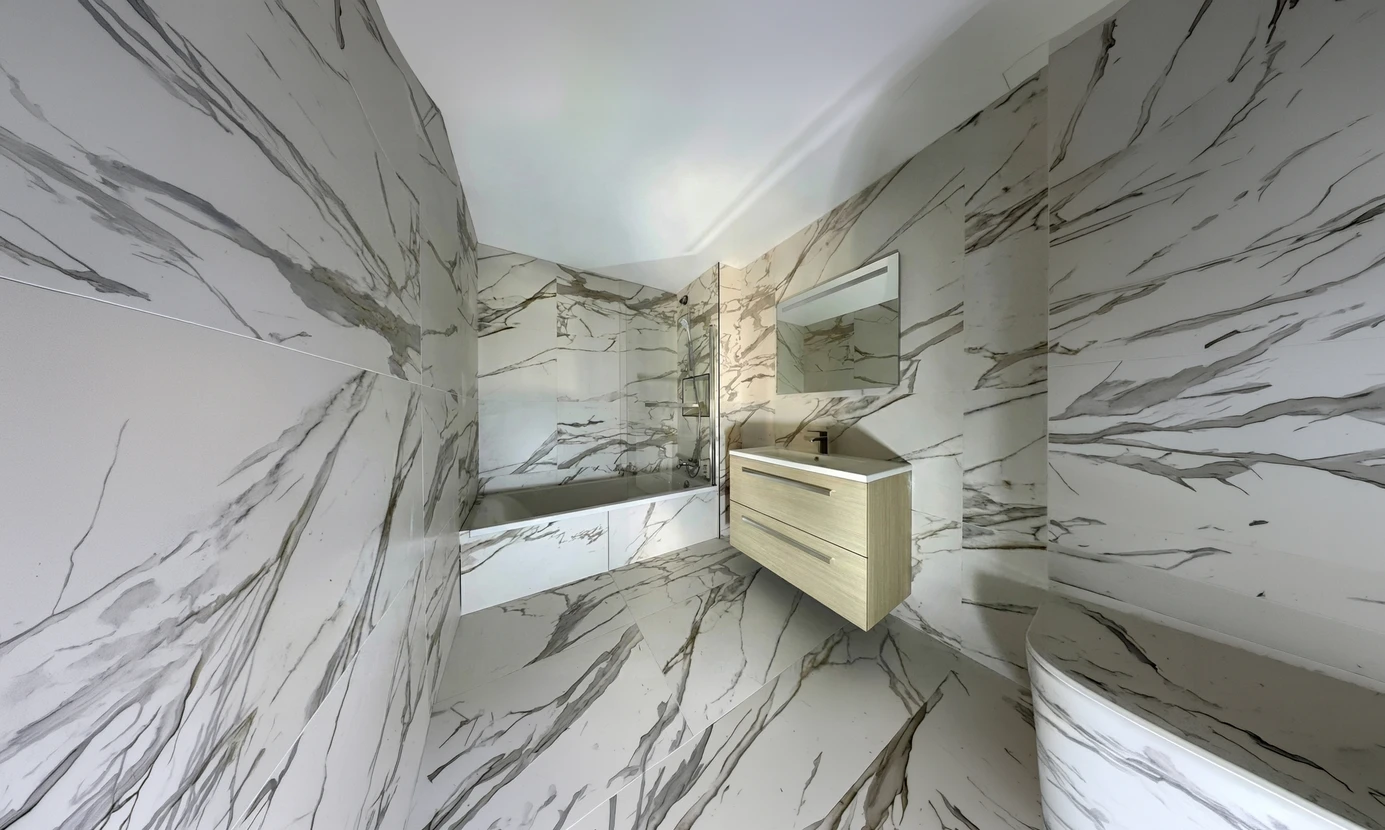 Salle de bain moderne enti&egrave;rement habill&eacute;e de grandes dalles effet marbre blanc vein&eacute; gris type Calacatta