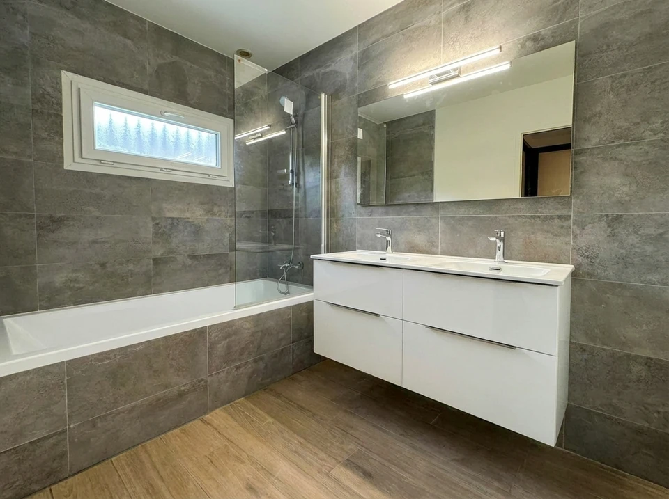 Salle de bain moderne avec meuble vasque blanc, lavabo à poser rond, robinetterie chromée classique