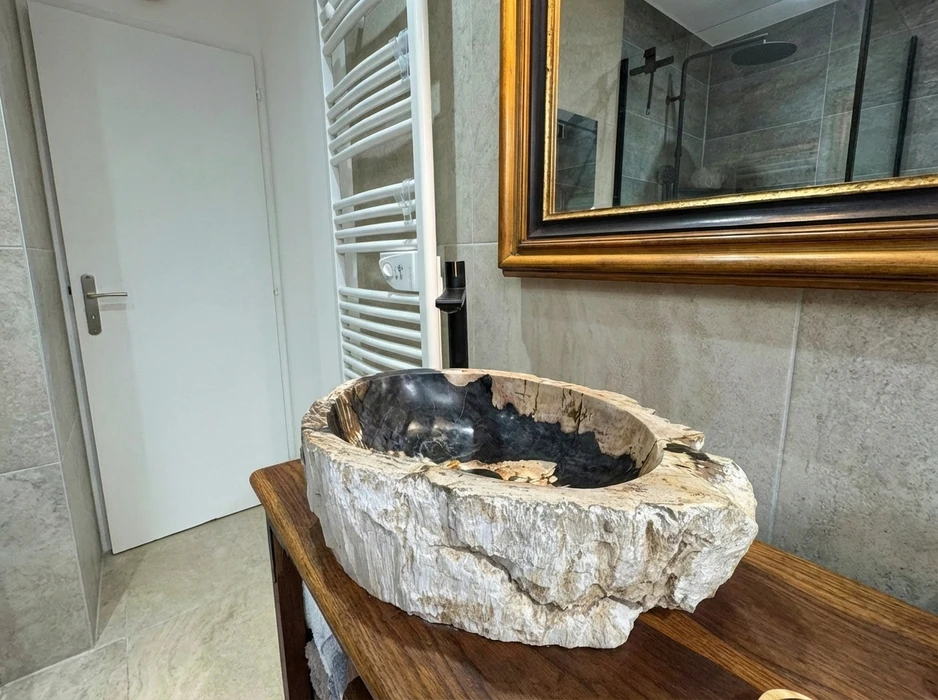 Salle de bains moderne avec baignoire encastrée blanche, paroi de douche en verre, colonne de douche chromée