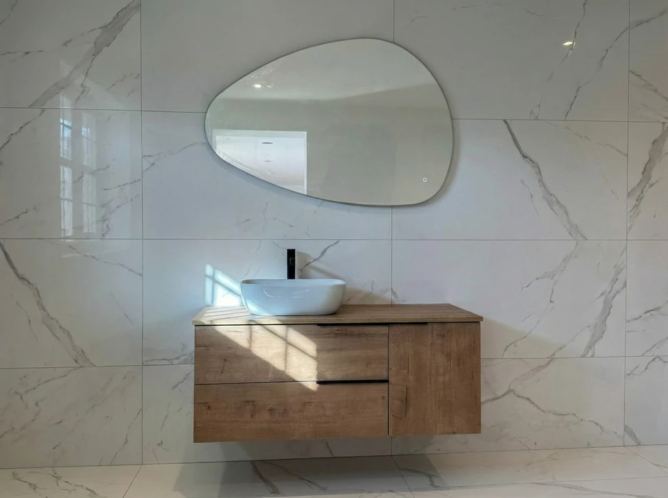 Salle de bain compacte avec douche à l'italienne en verre, vasque à poser ronde sur meuble en bois massif brut intégrant un lave-linge frontal blanc Candy
